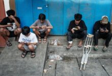 Jóvenes indonesios usando teléfonos móviles antes de la prohibición de redes sociales para menores de 16 años.