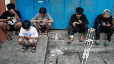 Jóvenes indonesios usando teléfonos móviles antes de la prohibición de redes sociales para menores de 16 años.